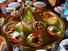 A large, round tray with a variety of small dishes
