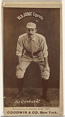 Man in baseball uniform hands on knees