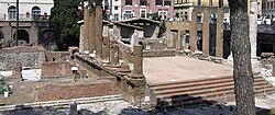 A photograph of Roman ruins in a modern street setting