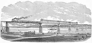 A train crosses an iron girder bridge