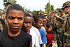 Haitian children queue at a humanitarian aid distribution site near a landing zone in Leogane, Haiti.