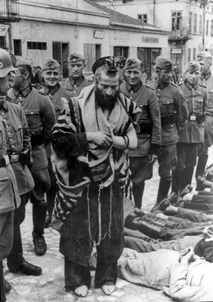 אחת התמונות שצולמה באירועי השפלת אולקוץ' - הרב משה הגרמן חבוש בתפילין מבוקעות, יחף ומושפל בידי חיילים גרמניים בכיכר השוק באולקוץ' (פולין), ביום רביעי, 31 ביולי 1940 כשלמרגלותיו שוכבים יהודים שהוכו ועונו.