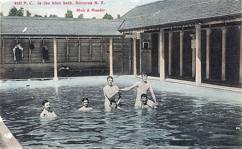 Carte postale colorisée d'hommes nus dans un bassin.