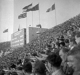 Spectators giving the Nazi salute during one of the medal ceremonies as the Nazi flag flies above