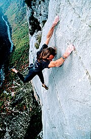 A climber free solo climbing on a rock face