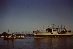 HMAS Supply being towed along the Brisbane river in late 1967