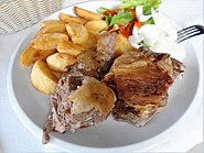 Roast lamb from a roasting spit, served with potato and onion in Istria County, part of Croatian cuisine