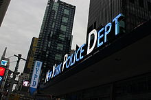 A glowing blue NYPD Times Sqaure sign with the initial letters in white