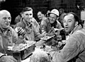 Des ouvriers de la Société Asbestos au moment de leur repas du midi, assis à des tables fournies par l'entreprise, juillet 1944.