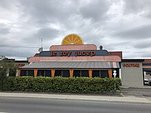 Restaurant with signs on front wall saying "le roy jucep" and "poutine"