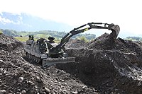 The two pivot points on the excavator arm of this AEV 3 Kodiak are clearly visible as it digs.