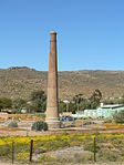 This old smoke stack, which dates from 1880, was erected by the then Cape Copper Company to provide energy to the nearby pumping engine so as to pump water from the mine shafts. In 1952 it was declared a monument in memory of the pioneer copper miners in. This old smoke stack, which dates from 1880, was erected by the then Cape Copper Company to provide energy to the nearby pumping engine so as to pump water from the mine shafts. In 1952 it was declared a monument in memory of the pioneer copper miners in