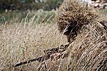 Sniper in a Ghillie suit with plant materials