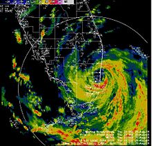 A colorized radar image of a hurricane over South Florida. Spiraling cyclonic bands, with a large area covered to the southeast, converge around a clear eye.