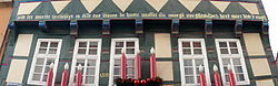 A Middle Low German inscription on a half-timbered house in Hameln, Lower Saxony that reads: Alle der warlde herlicheyt is alse ene blome de huete wasset un[de] morge[n] vorgheit. Des here[n] wort blift y[n] ewicheit. It is a passage from the First Epistle of Peter, and translates as 'All the world's magnificence is like a flower that grows today and vanishes tomorrow; the Lord's word remains in eternity.'[8]