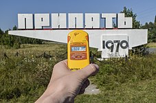 Pripyat city limit sign with a radiation dosimeter