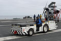 Tracteur de pont d'envol américain tirant un hélicoptère Sikorsky SH-60 Seahawk.