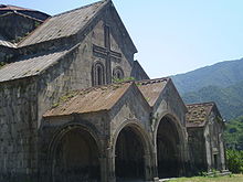 Gabled roof with extensions over a covered entrance with two gabled arches.