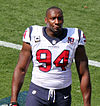 An African-American football player standing on a field with his helmet off