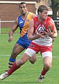 Canadian Aussie Rules player evades Nauruan opponent at 2008 International Cup.