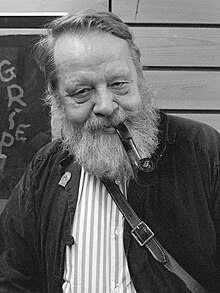 Black and white image of a man with a grey beard smoking a pipe