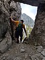 Hiker in the rock tunnel along trail 501 connecting Alben and Cima della Croce