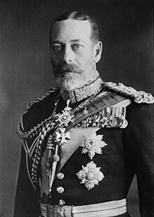 George V is pale-eyed, grey-bearded, of slim build and wearing a uniform and medals.