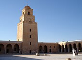 Vue du minaret depuis la cour. La face sud du premier niveau est percée, au-dessus de la porte, de trois fenêtres superposées de forme rectangulaire, qui n'ont pas les mêmes dimensions.