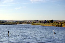 A lake with houses beyond