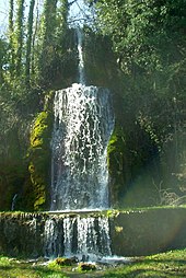 cascade sur trois niveaux, entourée de verdure