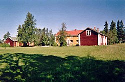 Læstadiuspörtet i juli 2004. Det röda pörtet syns till höger om den gula prästgården.