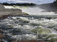 Des torrents dʼeau sont déversés par la chute du Calcaire. À lʼaval, lʼeau vive se fracasse contre des rochers.