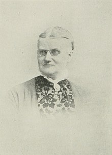 B&W portrait photo of a gray-haired woman with her hair in an up-do