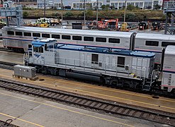 A gray diesel switcher locomotive with a blue roof
