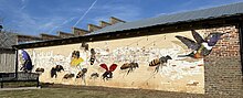 A mural primarily of pollinators including bees, butterflies, hummingbirds, and ladybugs
