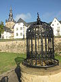 Schmiedeeisernes Gitter auf dem Brunnen in der neubarocken Grünanlage