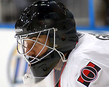 man wearing black goaltender mask and hockey equipment