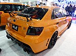 Subaru WRX STI tS type RA ("Record Attempt"), a higher-performance variant of the Subaru WRX STI sedan. This photo shows the rear of the car, which is orange with a small "tS" emblem on the right hand side.