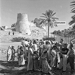 سياح يقفون لالتقاط صورة مع المحليين أمام القلعة. خمسينيات القرن العشرين.