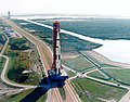 Photographie en couleur de la fusée Saturn V de la mission lors de son transfert vers le pas de tir.