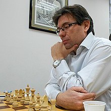 Gilles Mirallès looking over a chess board.