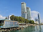 A ground view of the Limassol seafront, with the Trilogy buildings and the Limassol One building triumphing over the city