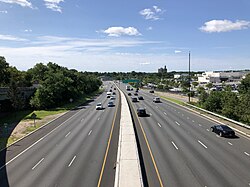 A wide road with many shops on both sides on a sunny day in Paramus