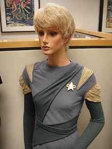 A photo of a mannequin wearing a costume, wig, and ear prosthetics.