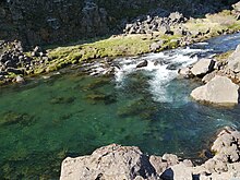 Une petite mare dans un torrent, dans un paysage rocheux.