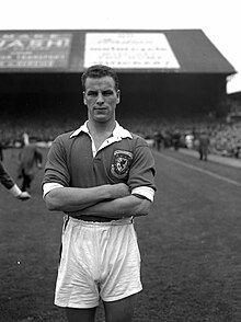 A footballer wearing full kit.