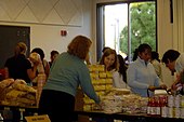 A food bank volunteer handing out food to people.