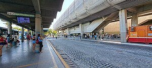 Vista de duas plataformas de embarque e desembarque de ônibus urbano do terminal Parangaba em julho de 2023. A direita da imagem, em destaque, a estação Parangaba do VLT e parte da estrutura dedicada do metrô.