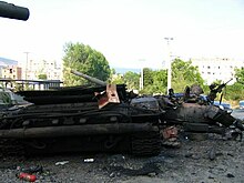 Burned tank amid other debris