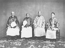 A photo of four elderly court officials sitting on chairs